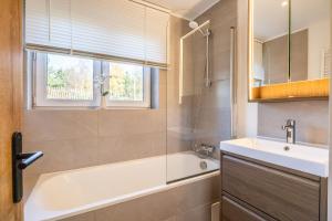 a bathroom with a tub and a sink and a window at Le Havre de la Forêt in Dochamps +27 photos