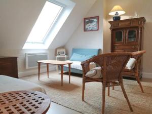 ein Dachzimmer mit einem Bett, einem Tisch und einem Stuhl in der Unterkunft Ker Eon - Les Gîtes de la Côte d'Amour in Batz-sur-Mer