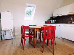 eine Küche mit einem Holztisch und roten Stühlen in der Unterkunft Ker Eon - Les Gîtes de la Côte d'Amour in Batz-sur-Mer + 18 Fotos