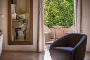 una silla sentada frente a un espejo en el baño en La Fiermontina Luxury Home Hotel, en Lecce