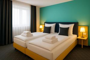 曼海姆AR Boutique Hotel Mannheim的酒店的客房 - 带2张带白色枕头的床