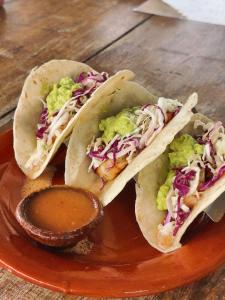 tres tacos en un plato con salsa sobre una mesa en The Sun Set, en Weligama