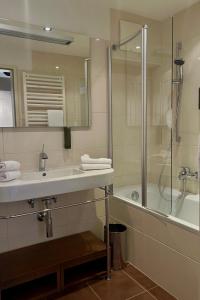 un baño con lavabo y ducha en Strandhotel Margaretha, en St. Wolfgang 51 fotos más