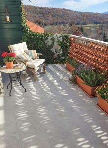 KatuniSun and Stone Cottage的一个带椅子和桌子的庭院,以及一些植物