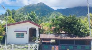 a small house with a mountain in the background at La Guerta Lodging House - Uno in Pintuyan