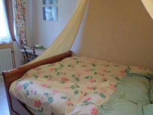 a bed with a comforter with flowers on it at Chambre d'hôtes à Vecoux in Vecoux