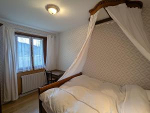 Chambre d'hôtes à Vecoux في Vecoux: غرفة نوم مع سرير مظلة ونافذة +12 صورة