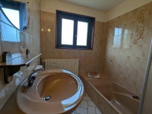 Chambre d'hôtes à Vecoux في Vecoux: حمام مع حوض استحمام ومغسلة وحوض استحمام