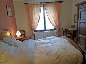 a bedroom with a white bed and a window at Chambre d'hôtes à Vecoux in Vecoux