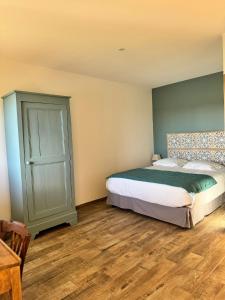 Un dormitorio con una cama grande y suelo de madera. en Chambre "Belle Etoile" Les Jardins de la Tuilerie, en Faverolles