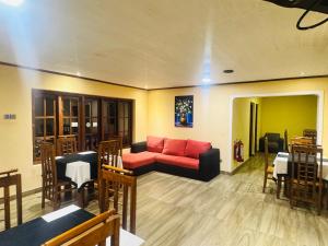 un salon avec un canapé rouge et une table dans l'établissement Blue Moon Hotel, à Nuwara Eliya