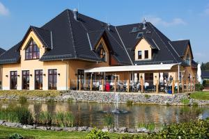 a large house with a pond in front of it at Holiday home in Markkleeberg near a lake in Markkleeberg