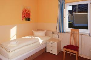 a bedroom with a bed and a window and a chair at Holiday home in Markkleeberg near a lake in Markkleeberg +29 photos