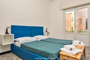 a blue bed in a room with a window at Tik Tok, TerreMarine in Bonassola +4 photos
