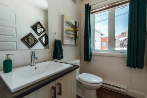 a bathroom with a sink and a toilet and a window at Spa privé et billard pret de la montagne de ski Stoneham 12 personnes in Stoneham +37 photos