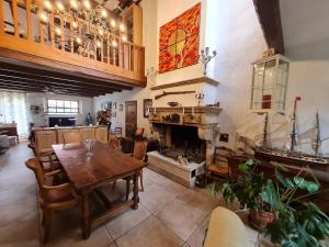 a dining room with a table and a fireplace at Au fil du temps 54 in Lironville