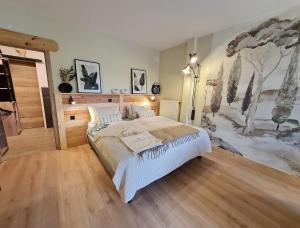 BoismontにあるChambre 1, La Perpontaiseの壁に絵が飾られたベッドのある寝室