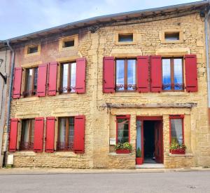 BoismontにあるChambre 1, La Perpontaiseの赤いシャッターと窓のあるレンガ造りの建物