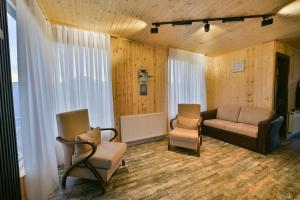 a living room with two chairs and a couch at Snow Heaven for 10 in Gudauri