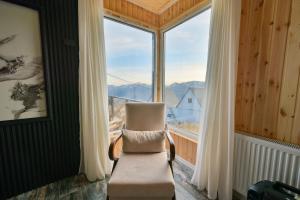 a chair in a room with a large window at Snow Heaven for 10 in Gudauri