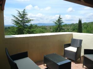einen Balkon mit Stühlen, Tischen und Aussicht in der Unterkunft Gîte de charme la Fenière in Joyeuse