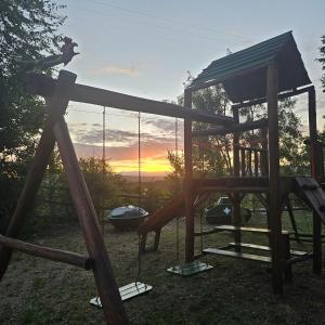 a wooden playground with swings and a swing at Sommerwind Cabañas in La Estancia