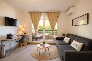 een woonkamer met een bank en een tafel bij T2, swimming pool, Tennis MC in Beausoleil