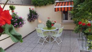 ein Tisch und Stühle auf einer Terrasse mit Blumen in der Unterkunft Les Glycines in Choloy