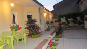 Un patio con mesa y sillas y flores. en Les Glycines, en Choloy