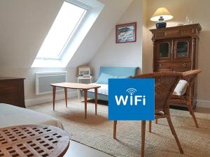 ein Wohnzimmer mit einem Witz-Schild auf einem Tisch in der Unterkunft Ker Eon - Les Gîtes de la Côte d'Amour in Batz-sur-Mer