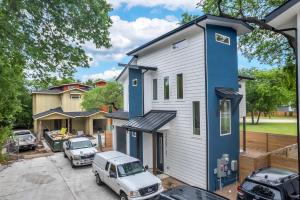 a blue and white house with cars parked in a parking lot at Queen Bed with Attached Private Bath in Austin