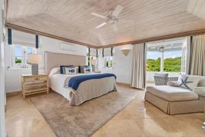 a bedroom with a bed and a couch and a fan at Royal Westmoreland - Villa Grove home in Saint James