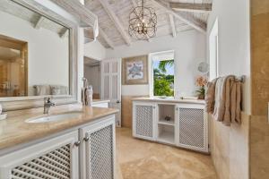 a bathroom with a sink and a large mirror at Royal Westmoreland - Villa Grove home in Saint James +9 photos