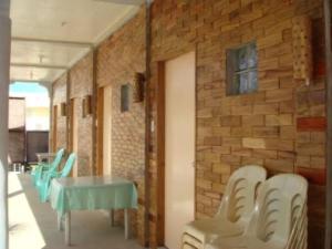 a room with a table and chairs and a brick wall at La Guerta Lodging House - Uno in Pintuyan