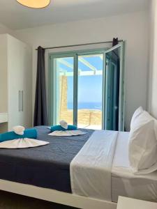 a bedroom with a large bed with a large window at Villa House Theasis in Kampos Paros