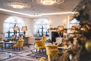 a hotel lobby with chairs and tables and windows at Kyniska Palace Conference & Spa in Mystras