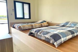 two beds sitting next to each other in a bedroom at 宜蘭好窄平價民宿 in Zhuangwei