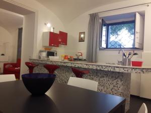 パレルモにあるA un passo dal Massimoのキッチン(テーブル、赤い椅子付)