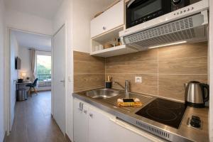 een keuken met een spoelbak en een magnetron bij T2, swimming pool, Tennis MC in Beausoleil