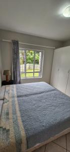 een slaapkamer met een groot bed en een raam bij The Flip Flop Stop in Ballito