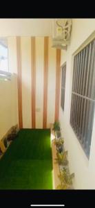 una stanza con un pavimento verde e delle piante al suo interno di Appartement Ode de paix a Cotonou Cadjehoun Altre 4 foto