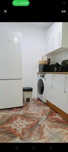 une cuisine avec des armoires blanches et un four à plaques de cuisson dans l'établissement Piso, à Valence