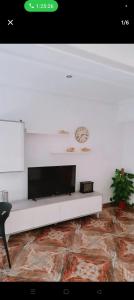 un salon avec une télévision sur un mur blanc dans l'établissement Piso, à Valence