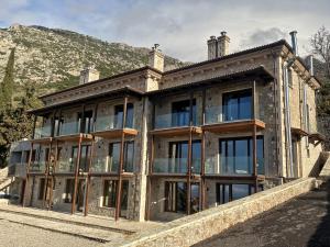 a large stone building with windows and a mountain at Evita BelleVue in Arachova