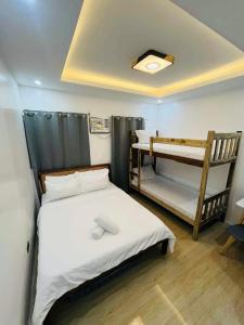 een kleine kamer met een bed en een stapelbed bij Aladdin's Guest House in Coron