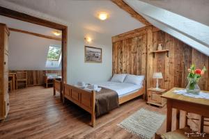a bedroom with a bed with a wooden wall at Zagroda Magija Bieszczady in Orelec