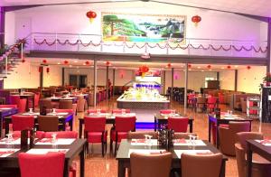 a dining room with tables and red chairs at Le CASTEL 22 in Châteaumeillant