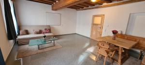 una sala de estar con una mesa y un sofá en ALTSTADT-Apartmenthaus BOGENSPERGER, en Braunau am Inn 17 fotos más