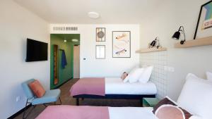 Una habitación de hotel con dos camas y una silla. en Hife Toulouse Sud Labège, en Labège