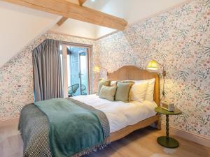 een slaapkamer met een groot bed met bloemenbehang bij 1 Bed in Alton oc-95760 in West Worldham